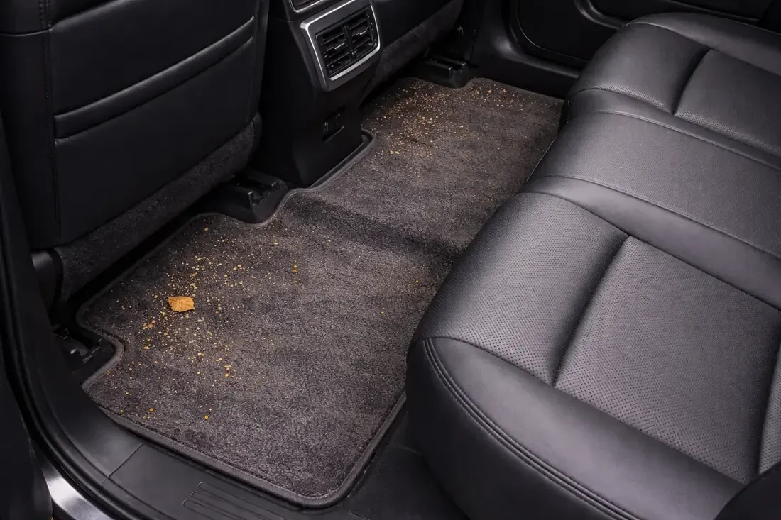 Piso trasero con la alfombra de fábrica sucia